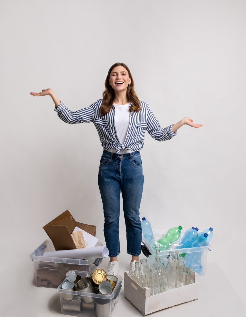 Waste Sorting. Millennial Lady Standing Among Containers With Different Materials For Recycling